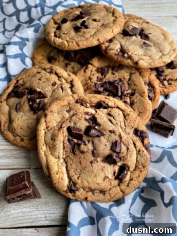 Another close-up of a warm, gooey Brown Butter Chocolate Chunk Cookie on a cooling rack, glistening with melted chocolate.