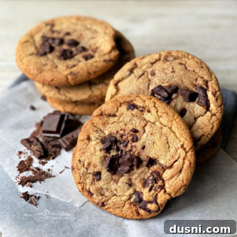 Close-up of freshly baked Brown Butter Chocolate Chunk Cookies on a wire cooling rack, showing crispy edges and soft centers.