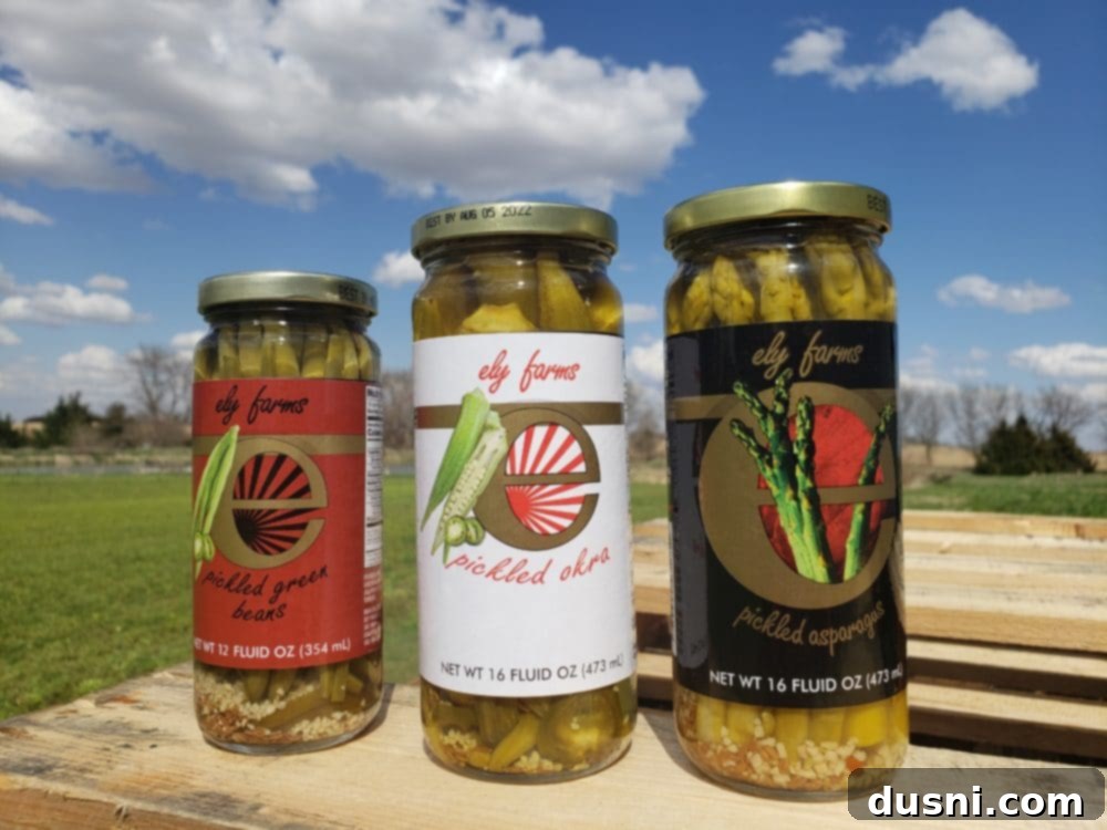 An assortment of Ely Farms pickled vegetable jars, including asparagus, okra, and green beans, representing a full case of delicious products.