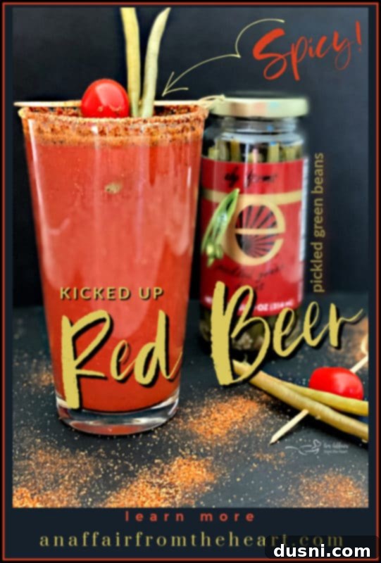 A beautifully composed Kicked Up Red Beer with a spicy rim and pickled green bean garnish, a visual invitation to try the recipe.