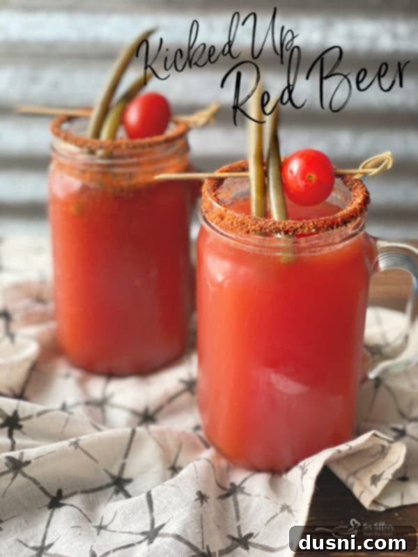 A hand raising a beer mug filled with Kicked Up Red Beer, ready for a toast to Ely Farms pickled green beans.