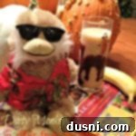 Dirty monkey cocktail with a stuffed monkey, a banana and a book on a table with text "dirty monkey"