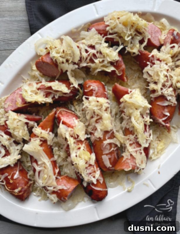 Grilled Kielbasa and Kraut 2 Delicious grilled Polish sausage and sauerkraut simmering in a pan