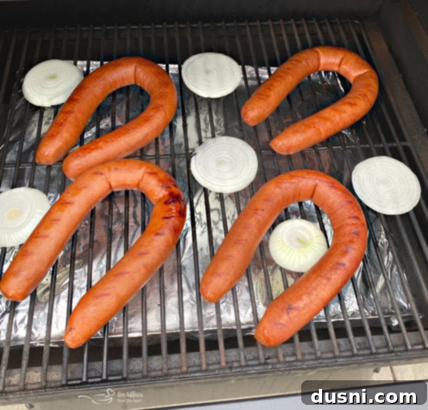 Grilled Kielbasa and Kraut 5 Sliced onions grilling on a barbecue grate with tongs