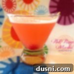 Pink PussyCat Martini in a martini glass with a multiple color background