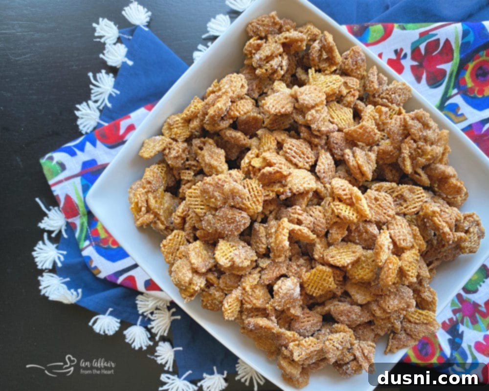 A bowl of Caramel Churro Chex Mix with a spoon