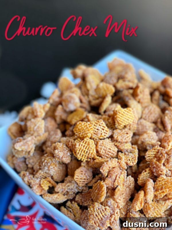 A bowl of Caramel Churro Chex Mix with a spoon
