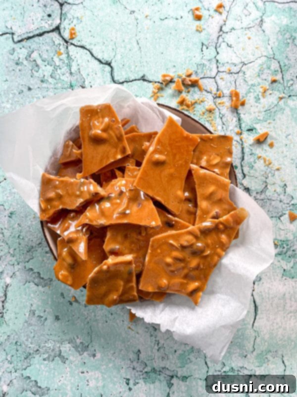 Homemade peanut brittle pieces served in a decorative bowl, ready to be enjoyed