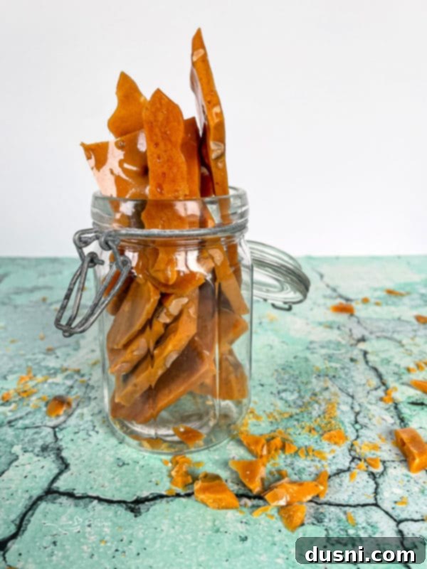Homemade peanut brittle neatly stacked in a glass jar, perfect for storage or gifting