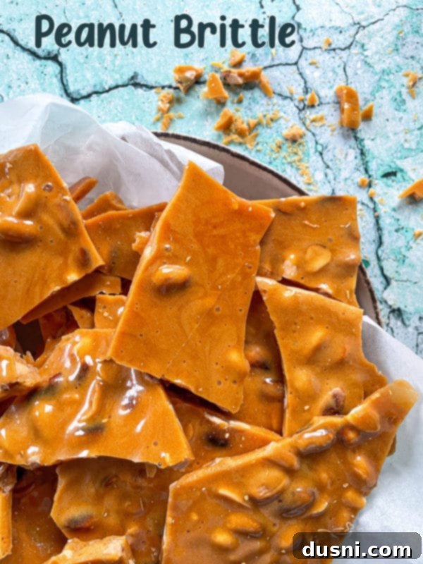 Homemade peanut brittle pieces arranged artfully on a white surface, ready to be enjoyed