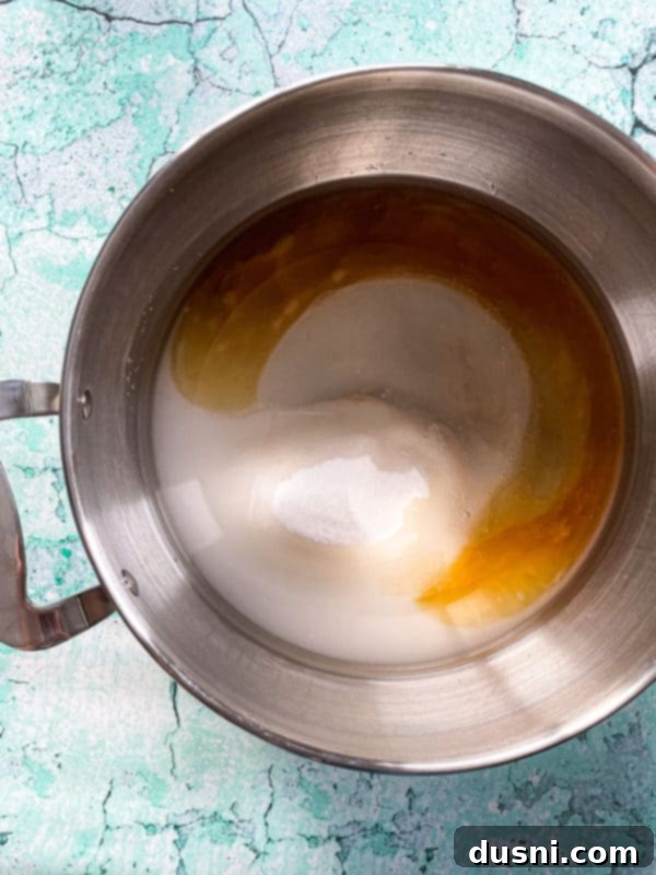 A baking pan lined with parchment paper, prepared for pouring hot peanut brittle mixture