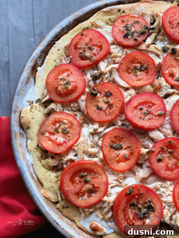 Delicious 5-Ingredient Chicken Pesto Pizza with fresh tomatoes, ready to eat.