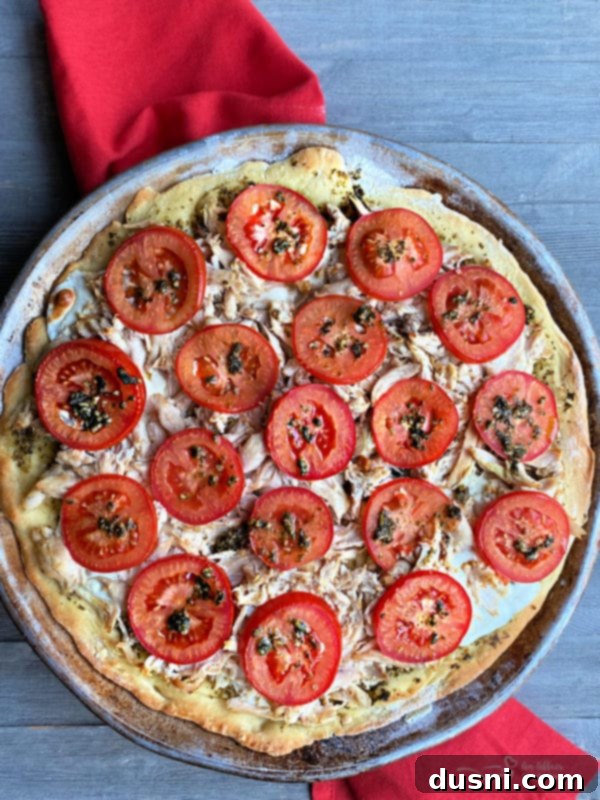 Preparing a quick chicken pesto pizza with fresh ingredients.
