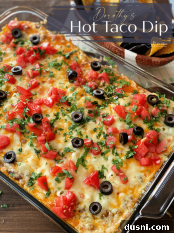 A large dish of Dorothy's Hot Taco Dip, garnished and ready to serve