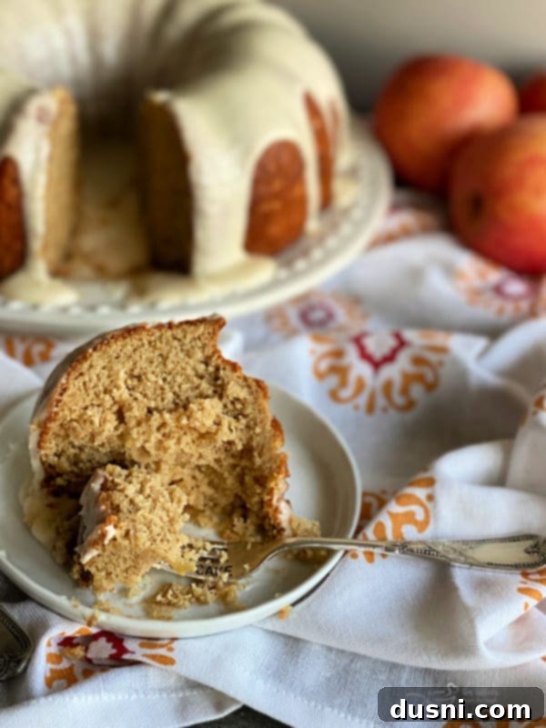 A slice of Caramel Apple Tea Cake on a plate with a fork.