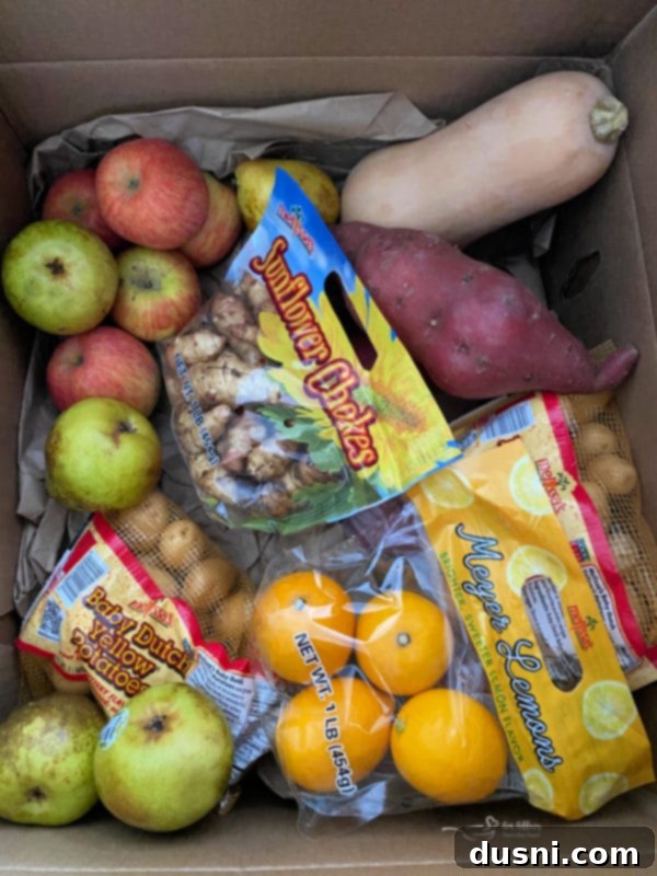 A large box from Melissa's Produce filled with various fresh fruits and vegetables, including yams, apples, pears, and squash.