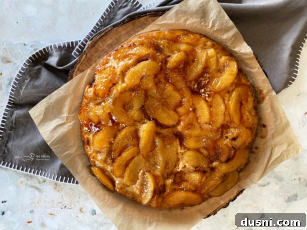 Golden brown apple upside down cake in a cast iron skillet, ready to serve.
