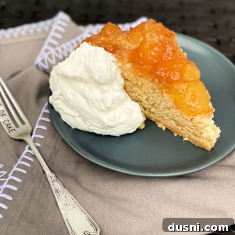 Close-up slice of apple upside down cake with visible apple chunks and moist cake.