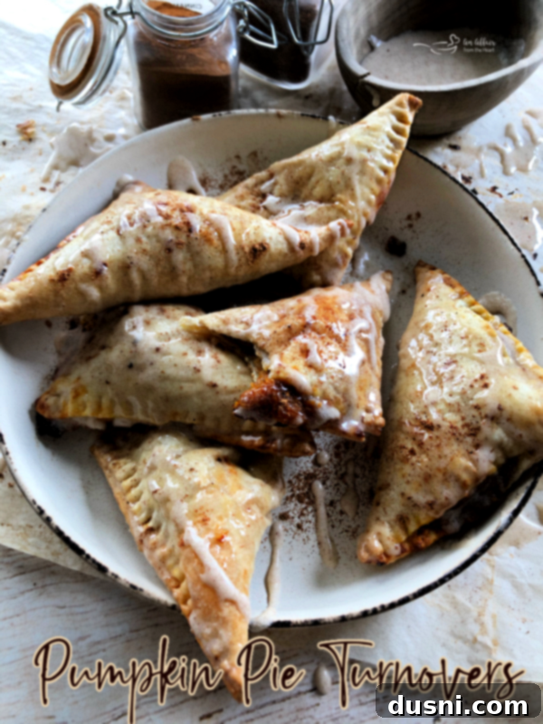 A hero shot of pumpkin pie turnovers, with some on a plate and others in the background
