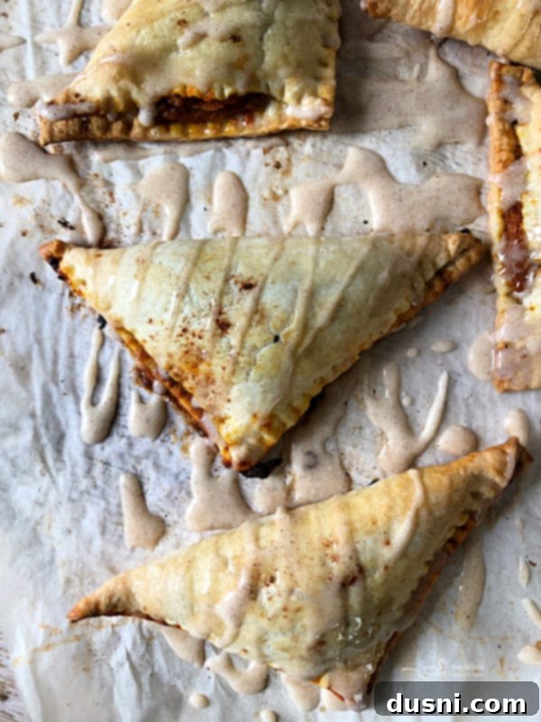 Close-up of a pumpkin pie turnover with spiced glaze drizzled on top