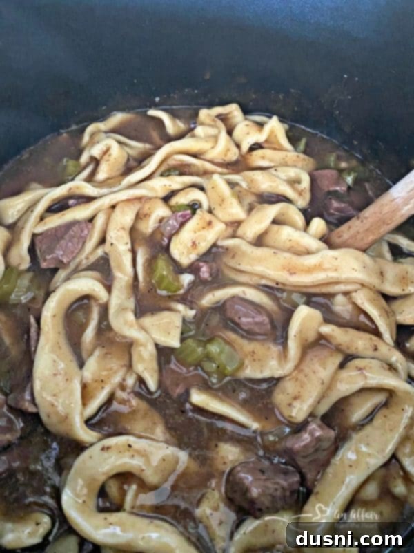 Close-up view of the beef and noodles in the pot, showcasing the perfectly thickened gravy coating all ingredients, ready for serving.