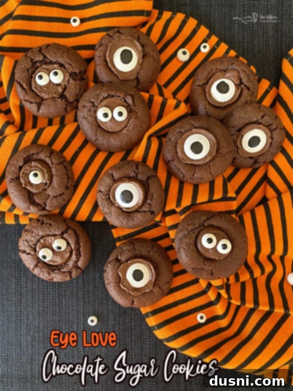 Sweet Gaze Chocolate Sugar Cookies 12 A plate of Halloween chocolate sugar cookies with candy eyeballs on a rustic wooden surface.