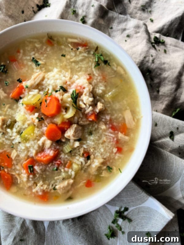 Instant Pot Chicken and Rice Soup in a white bowl with fresh parsley garnish