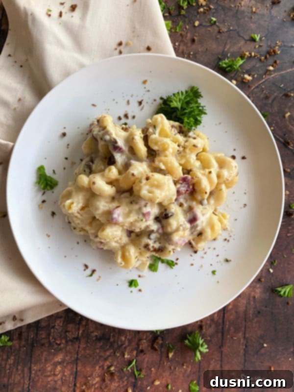 Reuben Mac 'n Cheese served in a bowl, showing creamy pasta, corned beef, and sauerkraut.