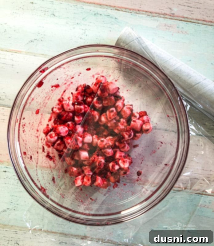 Step 3 in making Cranberry Fluff: A bowl of the cranberry, marshmallow, and sugar mixture, covered and refrigerating overnight.