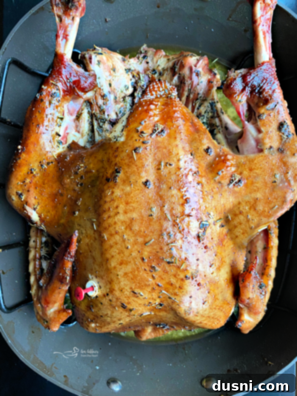 A whole smoked turkey on a carving board, with a smoke ring visible and golden-brown skin
