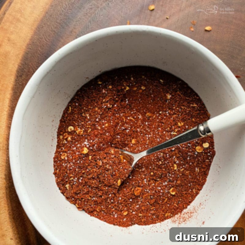 Homemade chili seasoning mixed in a small glass bowl, ready for use, with rich texture and color.