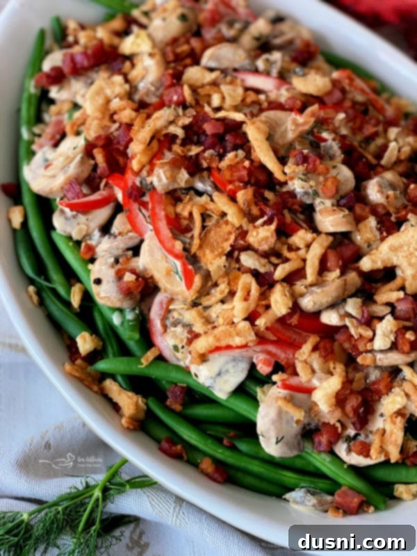 Sophisticated Green Bean Casserole in a white baking dish, garnished with crispy pancetta and onions