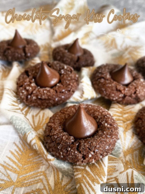 Sugar-Kissed Chocolate Delights 12 Close-up of three Chocolate Sugar Kiss Cookies on a wooden board