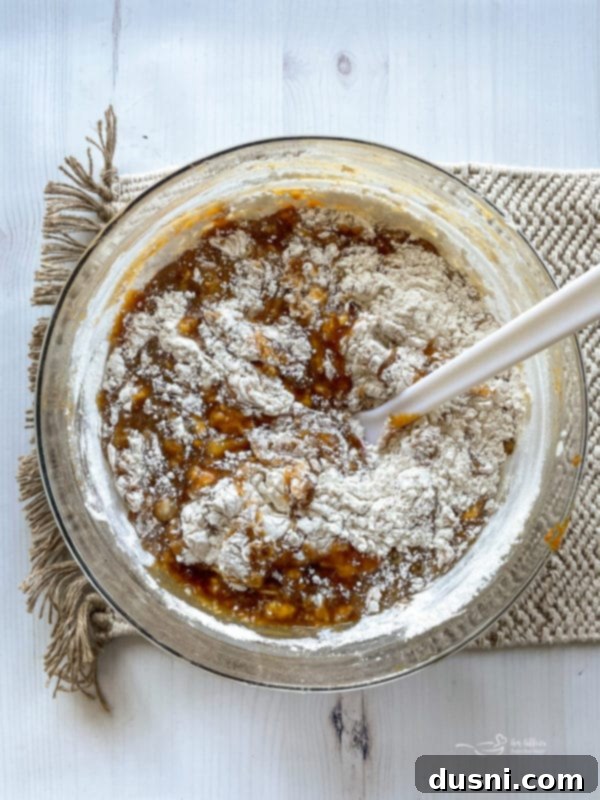 Mixing wet and dry pumpkin bread ingredients