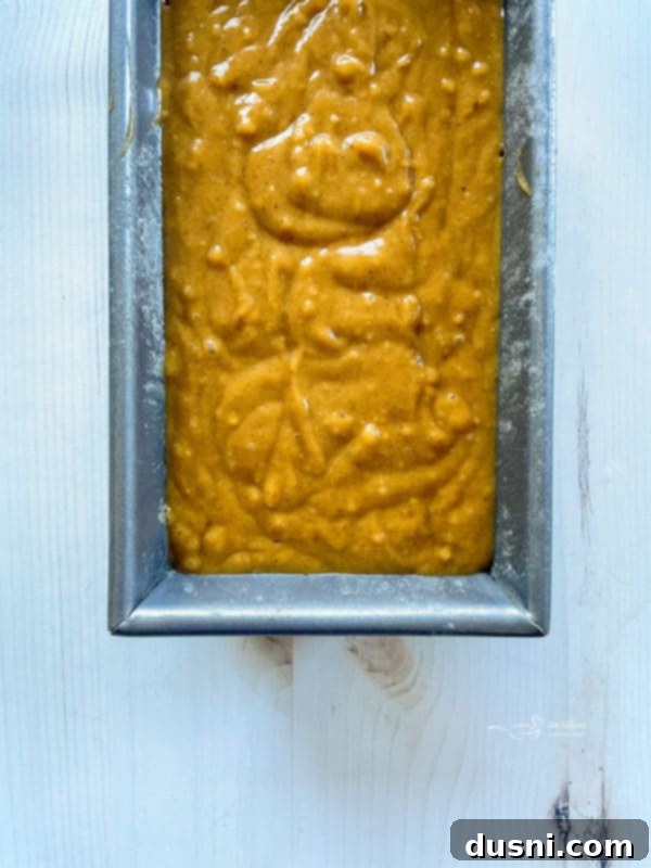 Uncooked pumpkin bread batter in a loaf pan