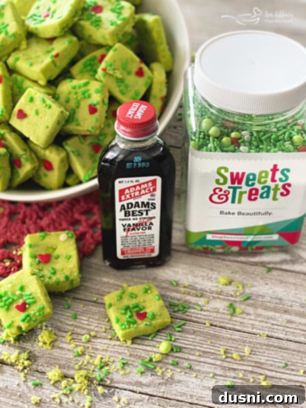 A plate of Grinch Shortbread Bites with a Christmas background