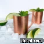 The Ginger Kick from Moscow 13 Side view of 2 Moscow Mule cocktail in a copper mug.