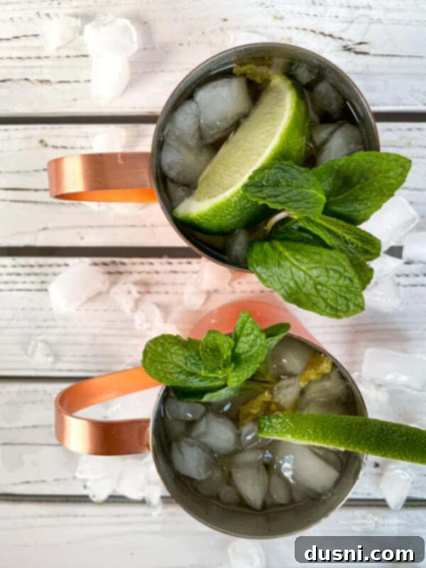 The Ginger Kick from Moscow 6 A hand holding a Moscow Mule in a copper mug with a lime garnish.