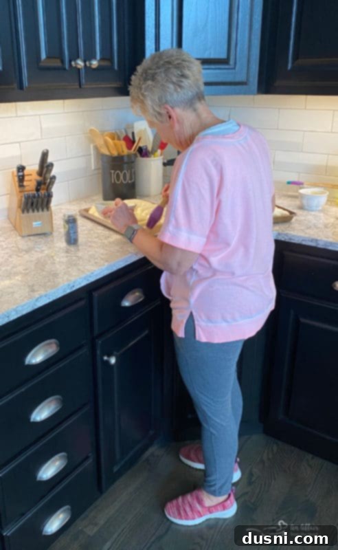 Risen dough rolls on a baking sheet, significantly larger than their initial size, ready for baking.