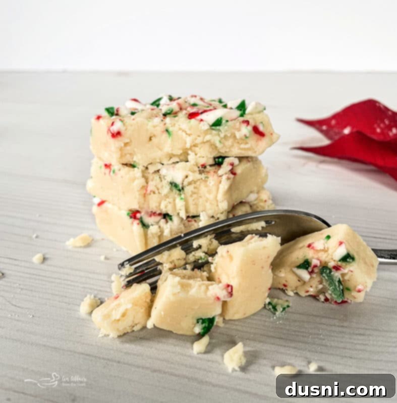 White chocolate peppermint fudge on a festive green plate with a fork.