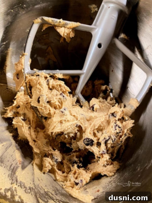 Cookie Dough Brownie Dream 4 Ingredients for making homemade brownies laid out on a wooden surface, including chocolate, butter, sugar, and flour.