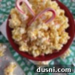 Peppermint Bark Popcorn Delight 13 Close up of Peppermint Candy coated popcorn and 2 candy canes in a red bowl
