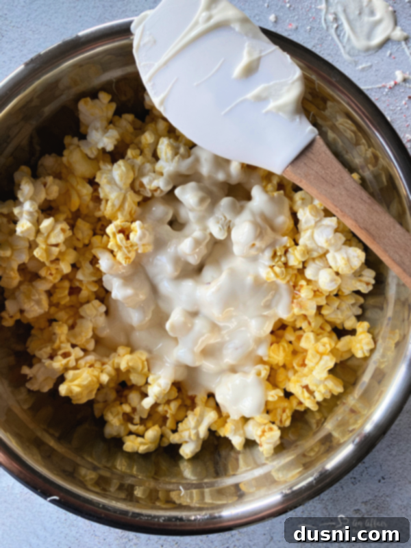 Peppermint Bark Popcorn Delight 4 Ingredients laid out for peppermint bark popcorn, including popcorn bags, almond bark, vegetable oil, and crushed candy canes.