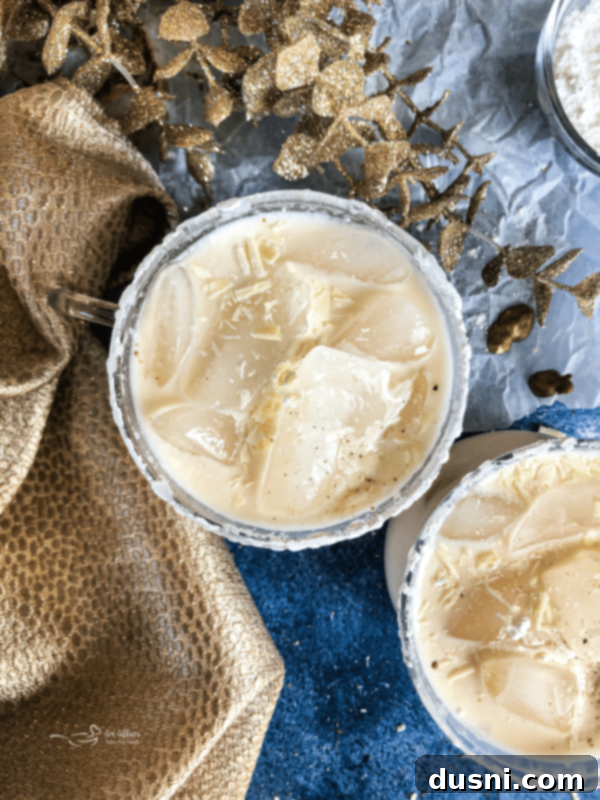 White Russian Cocktail close up on blue background, a classic creamy coffee-flavored drink.