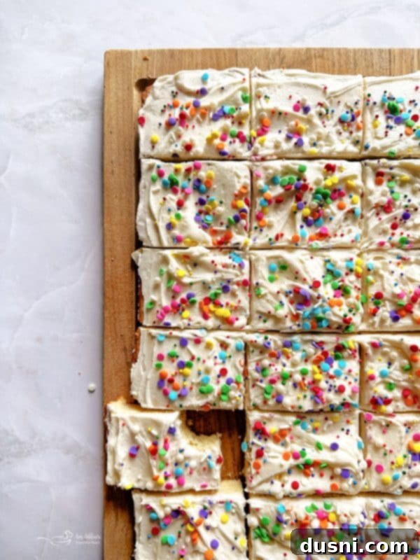 Delicious Frosted Sugar Cookie Bars with festive sprinkles on a serving platter.