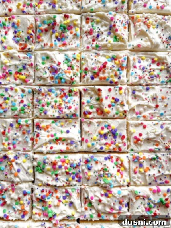 A close-up of a frosted sugar cookie bar with intricate swirl frosting design.