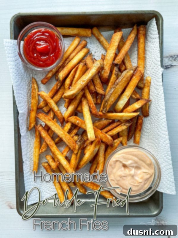 Top view of fries on baking sheet with ketchup, enticing viewers to try the recipe.