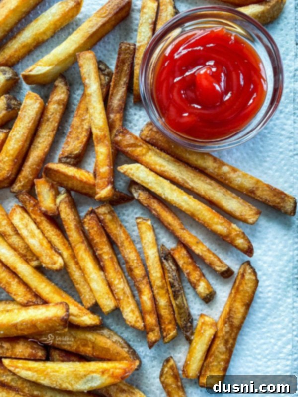 Close view of double fried french fries with ketchup, highlighting their golden brown exterior.