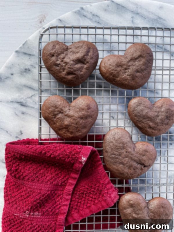 Baked heart-shaped chocolate whoopie pie cakes cooling on a rack