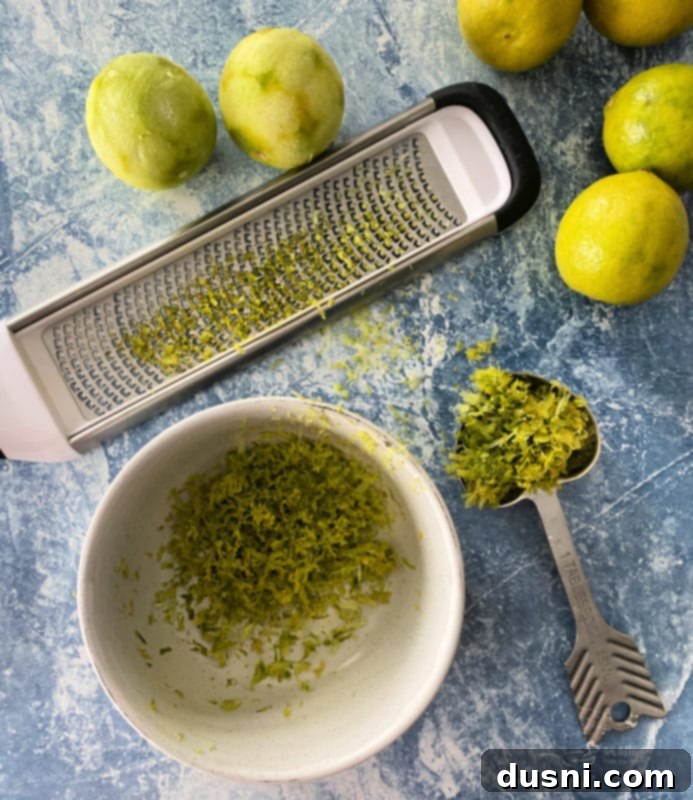 Zesty Key Lime Sheet Pie 5 A slice of Key Lime Slab Pie garnished with lime slices and raspberries, ready to be served.